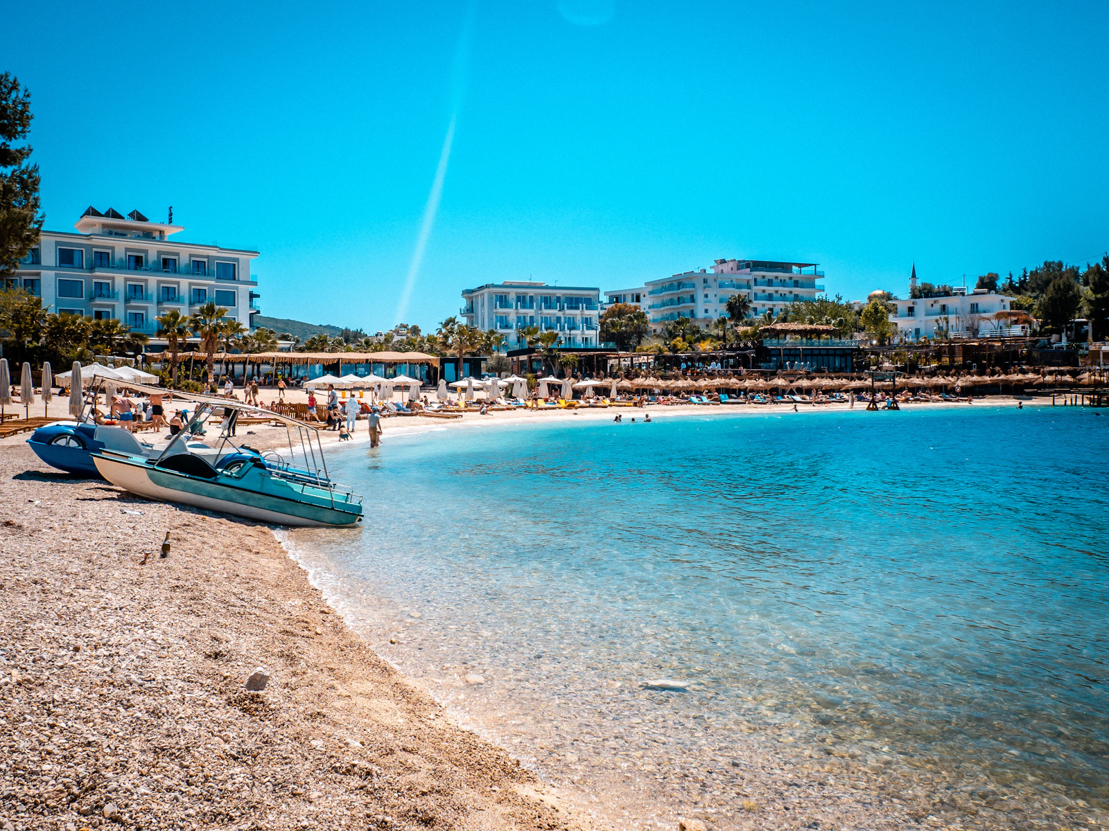 Plage turquoise de la Riviera albanaise avec eaux cristallines et stations balnéaires