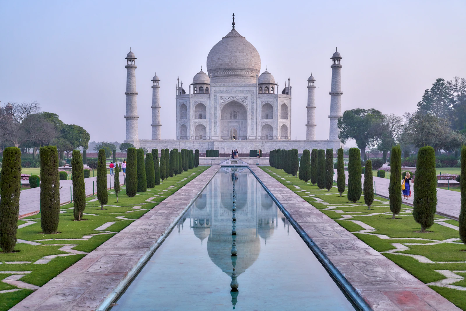 Le Taj Mahal d'Agra se reflétant dans les bassins au lever du jour