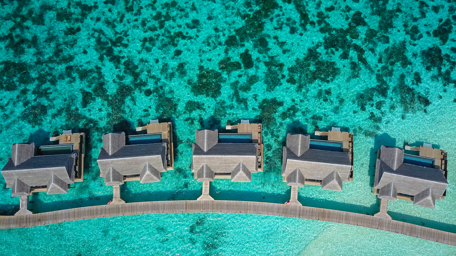 Vue aérienne de bungalows sur pilotis sur un lagon turquoise des Maldives