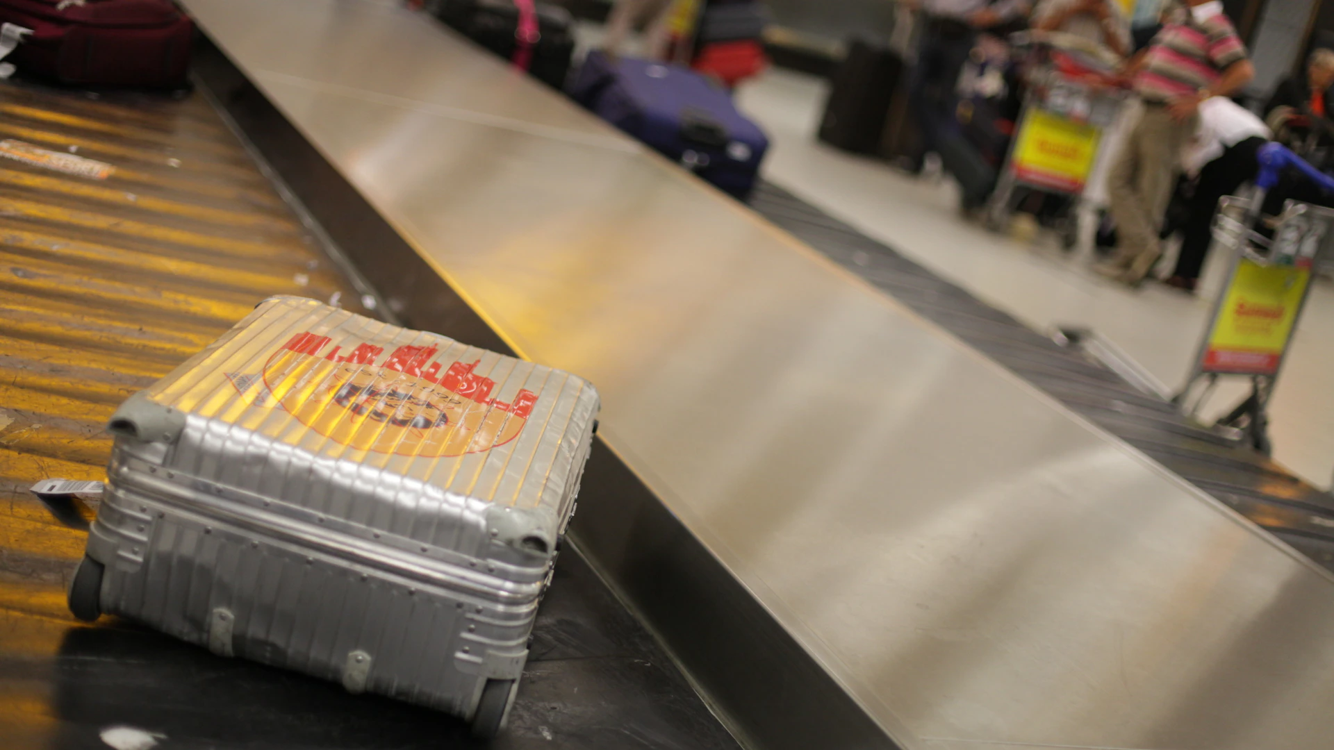 Valise cabine rigide grise posée dans un aéroport