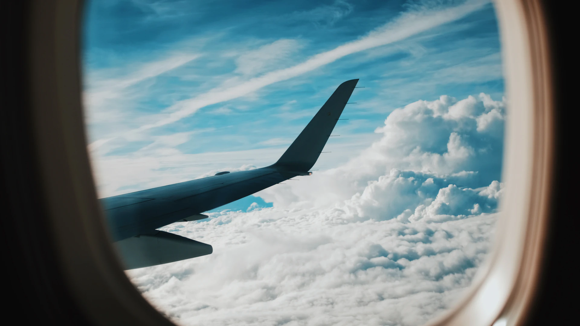 Aile d'avion vue du hublot au-dessus des nuages en plein vol