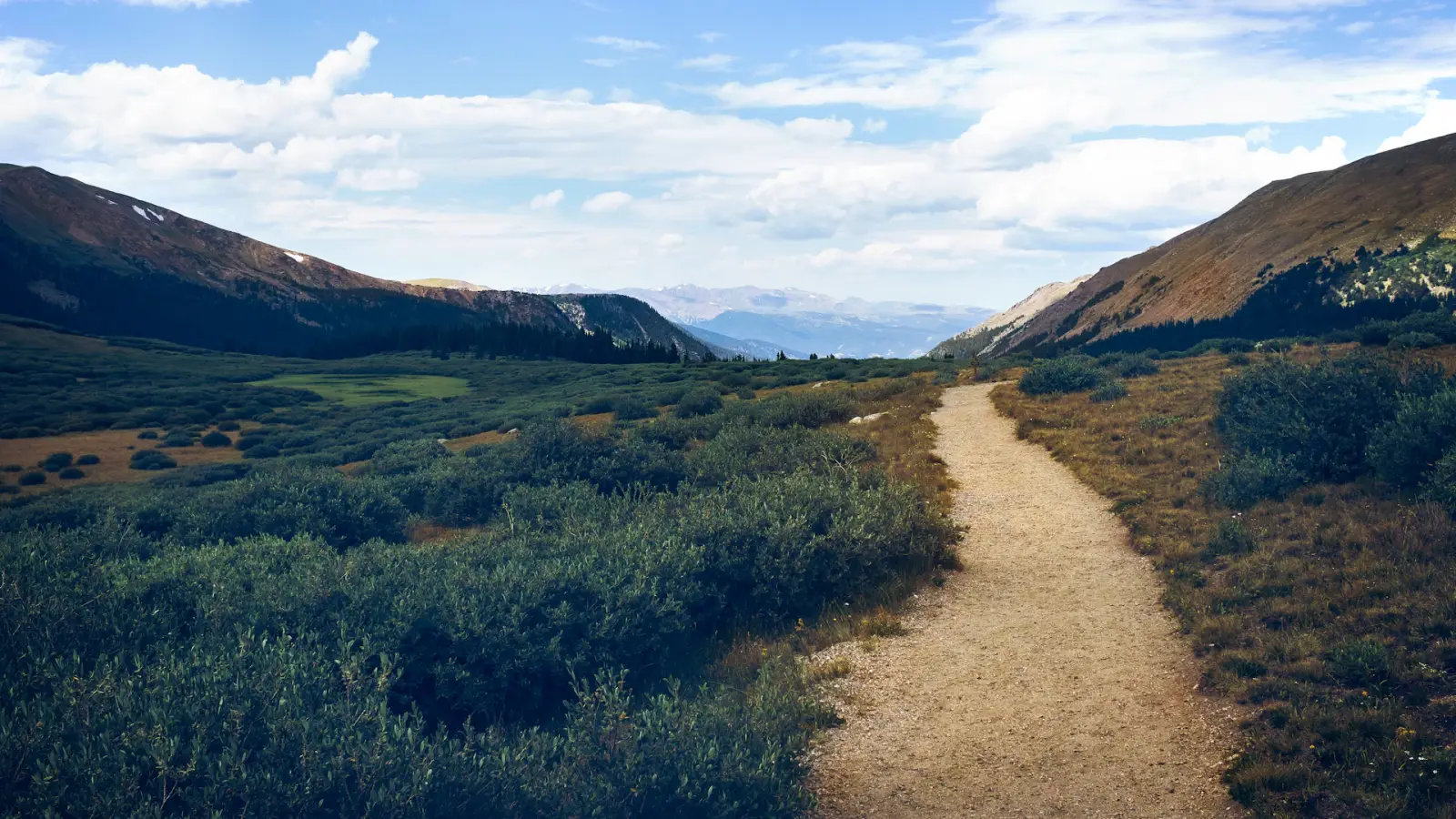 Sentier serpentant dans une vallée de montagne déserte et préservée