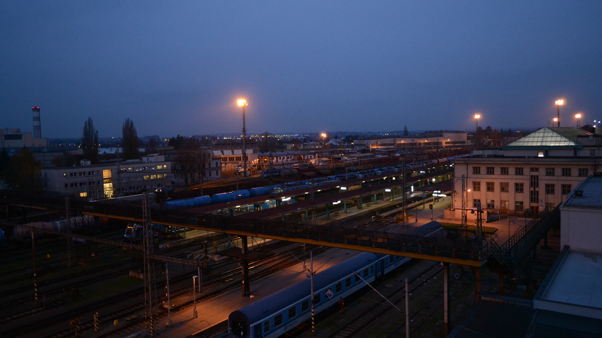 Quai de gare illuminé au crépuscule avant le départ d'un train de nuit