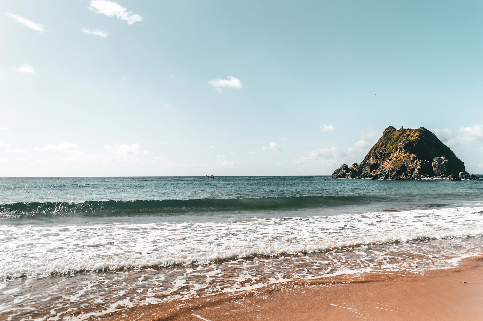 Plage de sable doré et rocher volcanique à Fernando de Noronha
