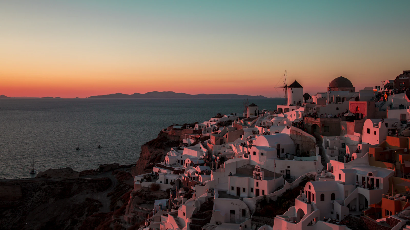 Maisons blanches et dômes bleus d'Oia surplombant la caldeira de Santorin